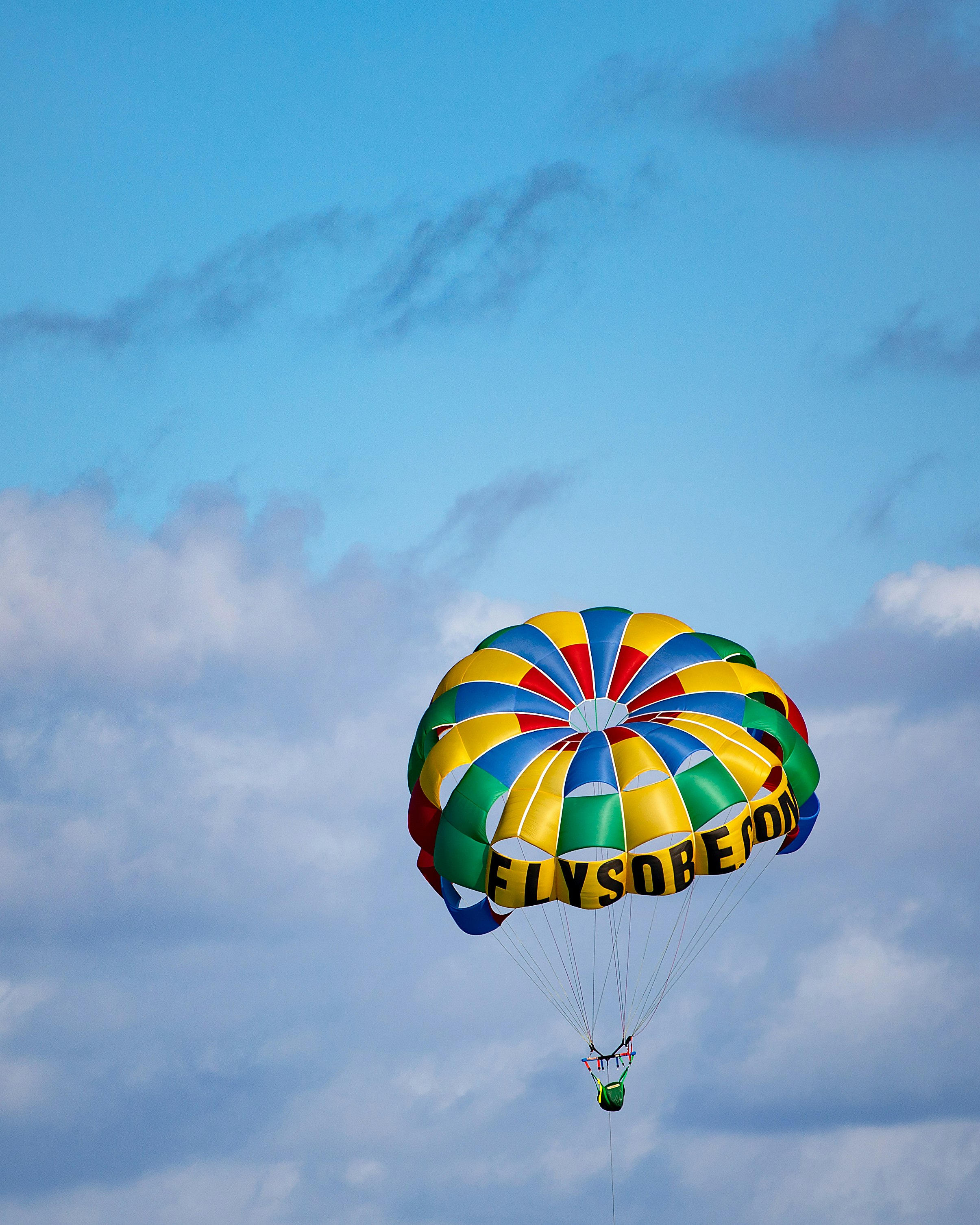 yellow blue and red hot air balloon in mid air under cloudy sky during daytime